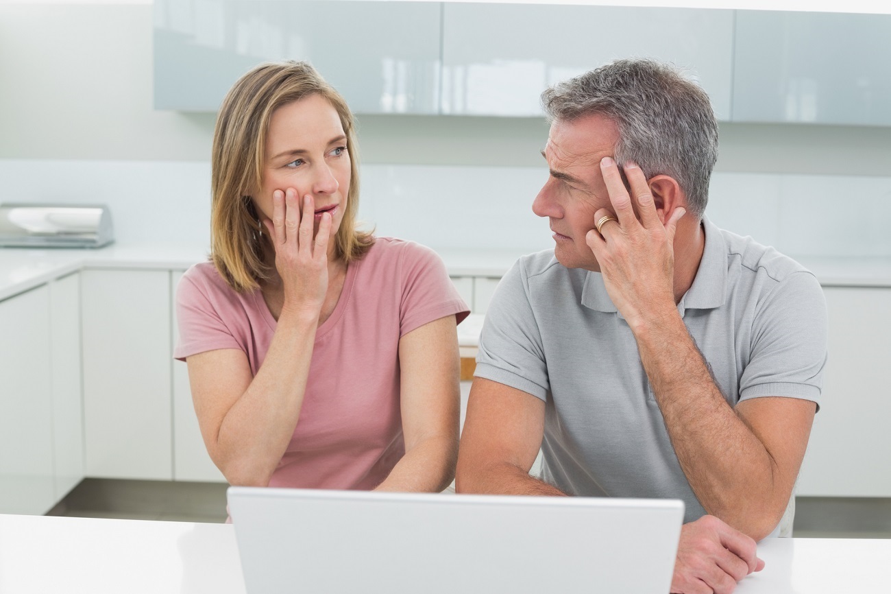 Shocked couple using laptop in the kitchen at home Facing Foreclosure? Know Your Alternatives